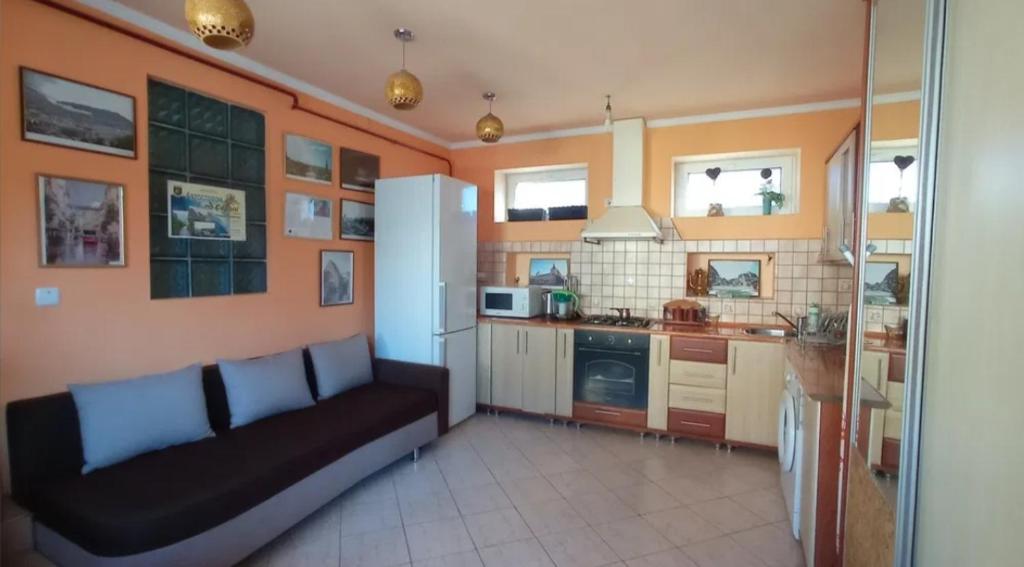 a kitchen with a black couch in a room at Затишні Апартаменти Берегове in Berehove