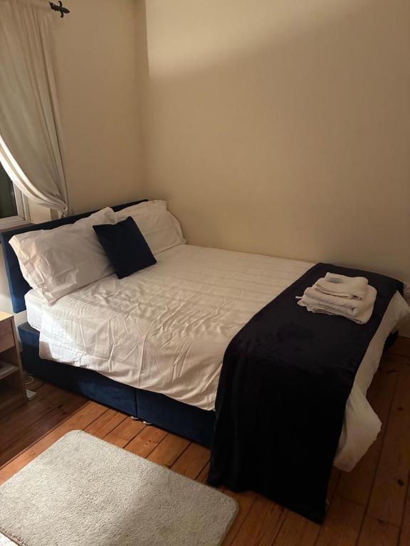 a small bedroom with a bed with white sheets and a rug at Ríocht Fódla 3 in Killarney