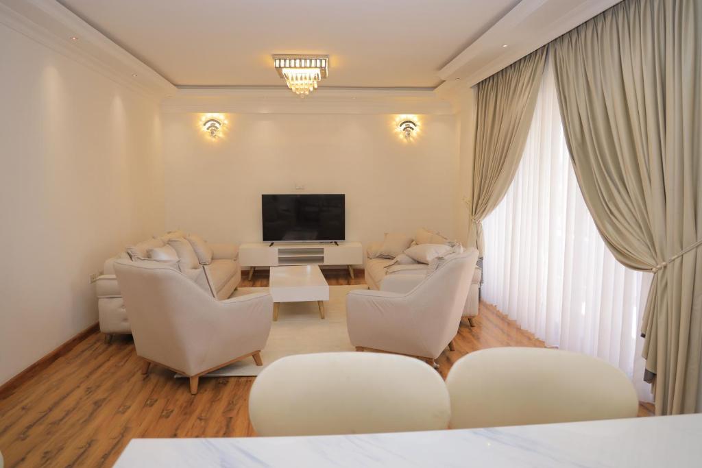 a living room with white furniture and a flat screen tv at Abat property Rental in Addis Ababa