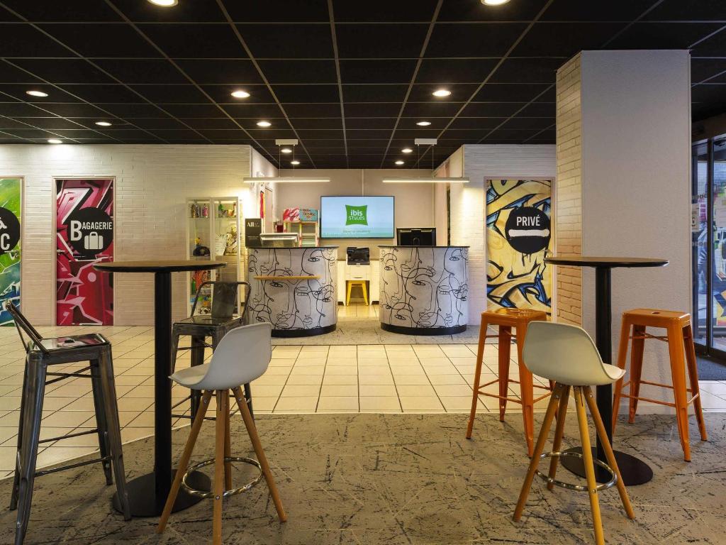 a room with tables and stools in a store at Ibis Styles Toulouse Centre Canal du Midi in Toulouse