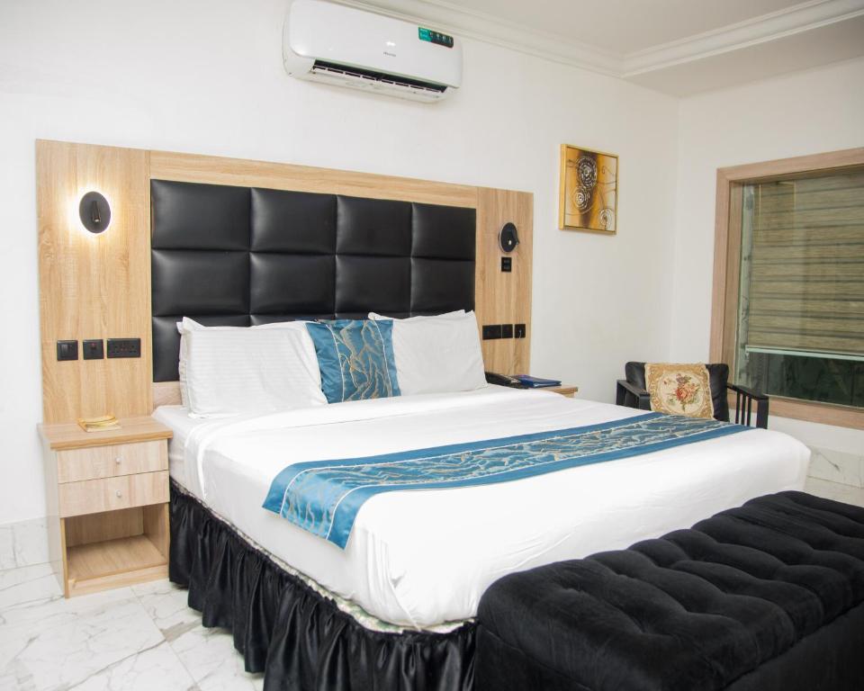 a bedroom with a large bed with a black headboard at Golden Tulip Hotel in Asaba
