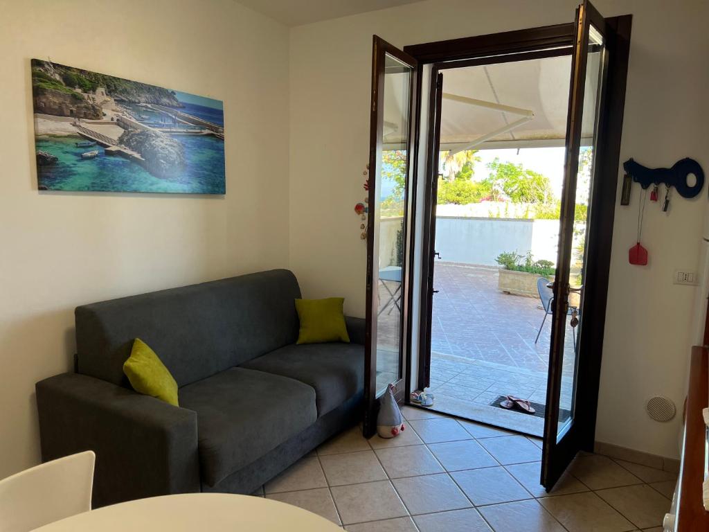 a living room with a couch and a sliding glass door at Solemar Salento in Marittima