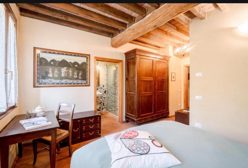 a bedroom with a bed and a desk and a table at La Locanda di Diogene in Case Reggiani