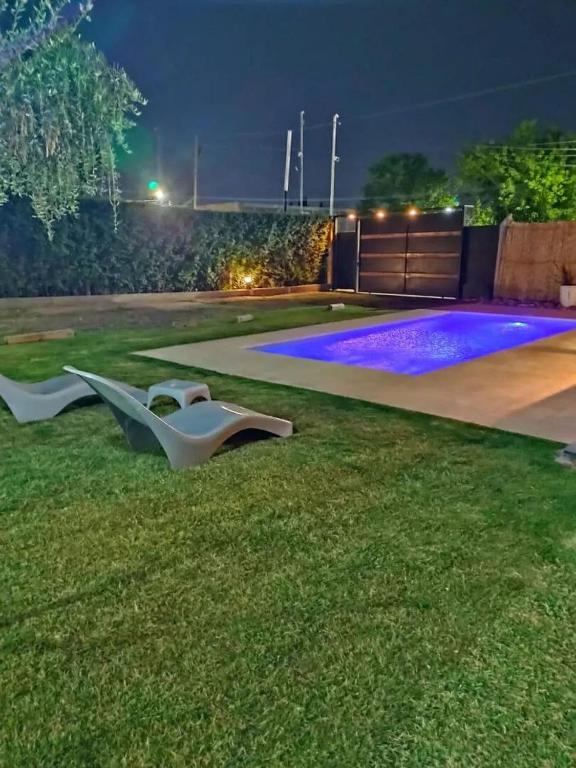 a backyard with a swimming pool at night at Complejo Los Olivos in Ciudad Lujan de Cuyo