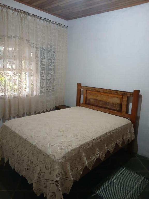 a bedroom with a bed and a window at Recantos das Avencas in Água Boa