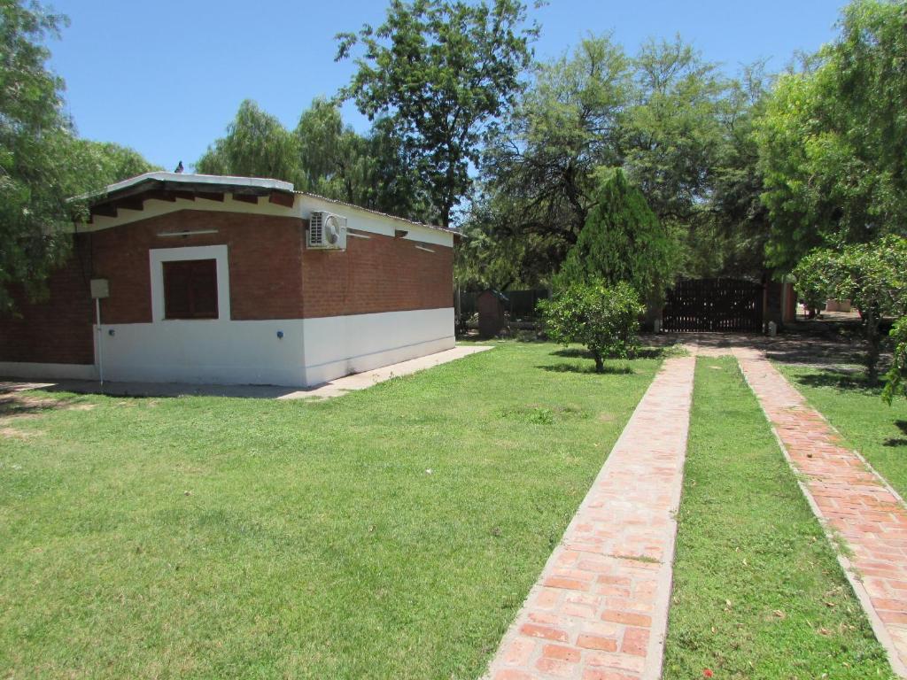 a brick building in a yard with a grass field at Complejo Kallpa in Santiago del Estero