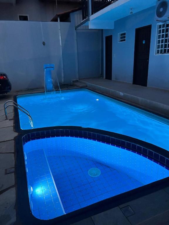 a large swimming pool with blue lighting in a house at Pousada Cantinho da Jú in Pirenópolis
