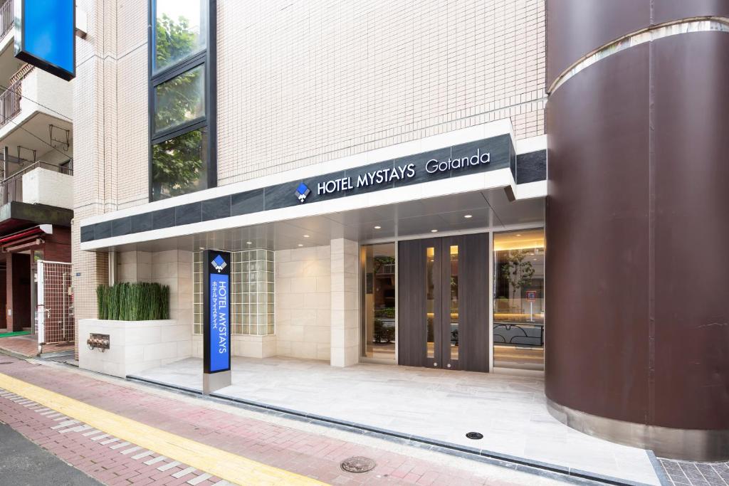 a building with a sign for the jones interests group at HOTEL MYSTAYS Gotanda in Tokyo