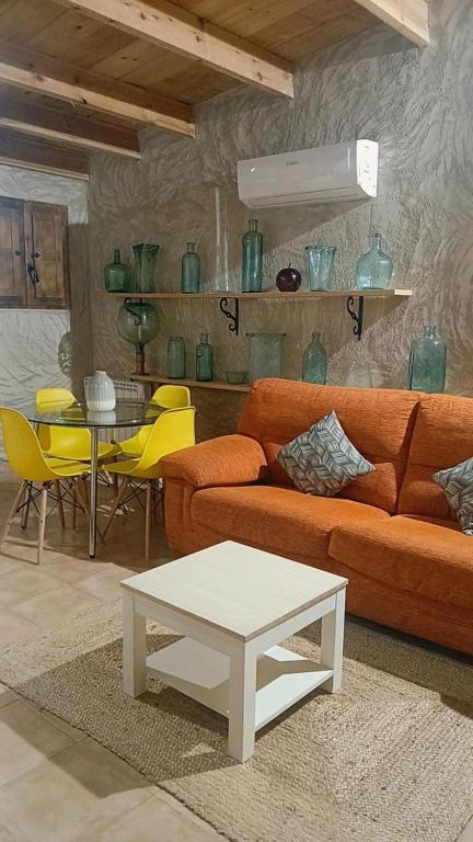 a living room with a couch and a table and chairs at Casa Estrella in Villafamés