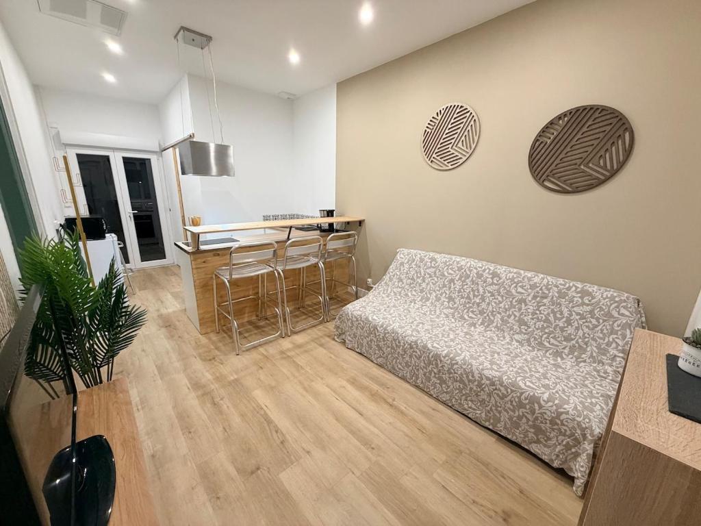 a living room with a bed and a kitchen at La Maison du Souvenir in Beaucourt-sur-lʼAncre