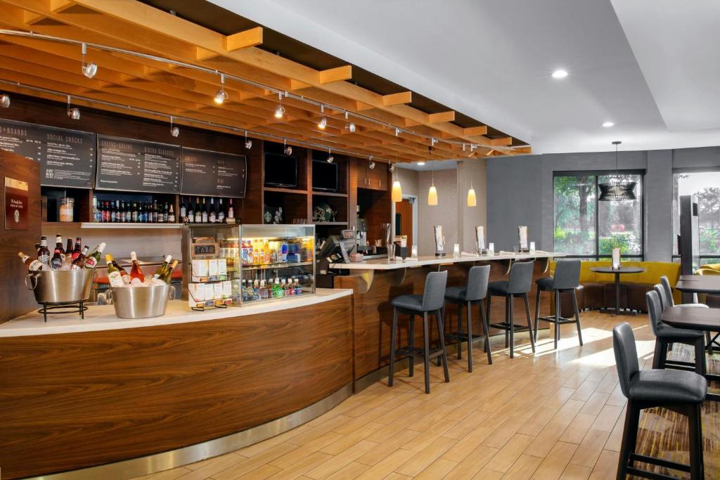 a restaurant with a bar with stools at Courtyard by Marriott Jacksonville I-295/East Beltway in Jacksonville