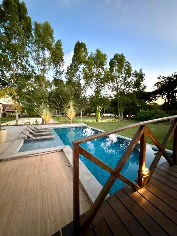 a swimming pool with a wooden deck next to at Casa Amaré Barreirinhas in Barreirinhas