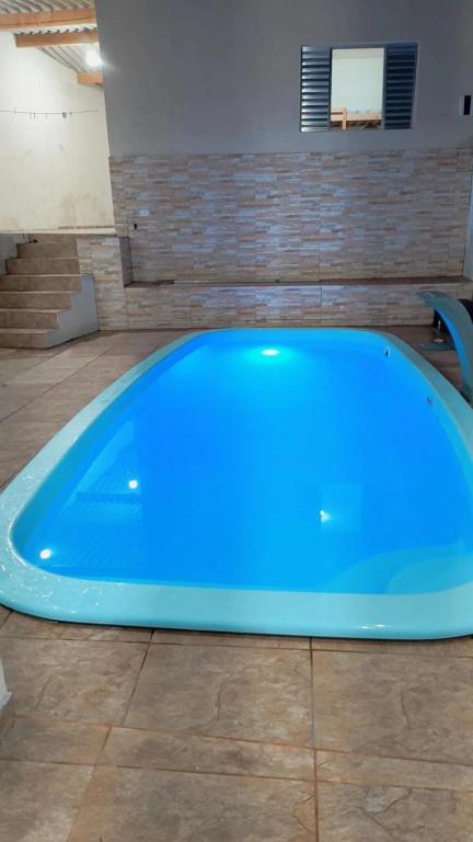 a blue tub in a room with a tile floor at Casa com piscina in Suzano