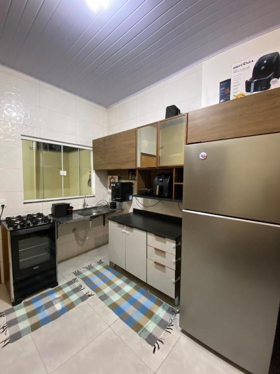 a kitchen with a stainless steel refrigerator and cabinets at Apto Aconchegante Próximo ao Centro! in Sinop