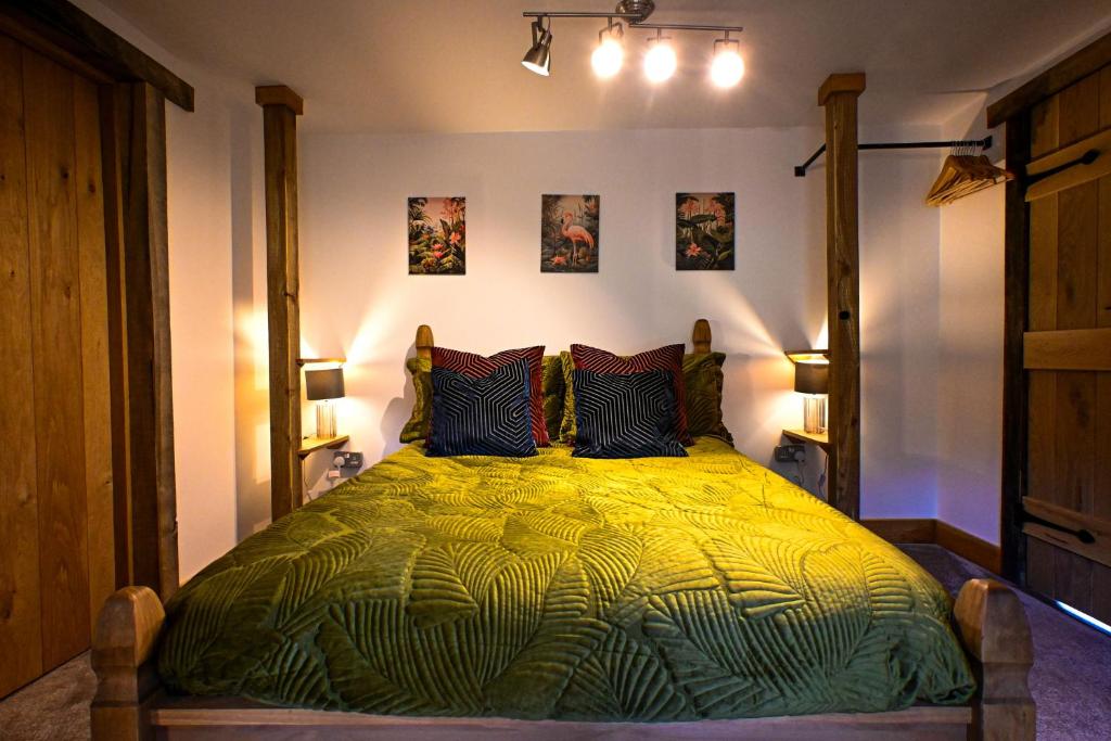 a bedroom with a large bed with a green comforter at Pooh Corner in Hythe