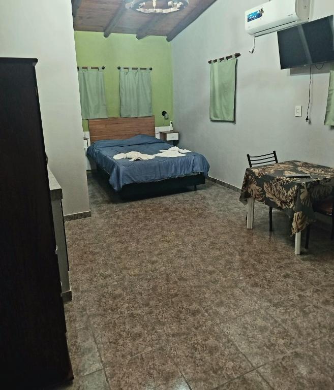 a bedroom with a bed and a table in it at Monoambiente Pilu in Villa Cura Brochero
