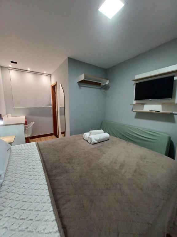 a bedroom with a large bed and a flat screen tv at Riviera Sanary 1206 - Nova Almeida in Serra