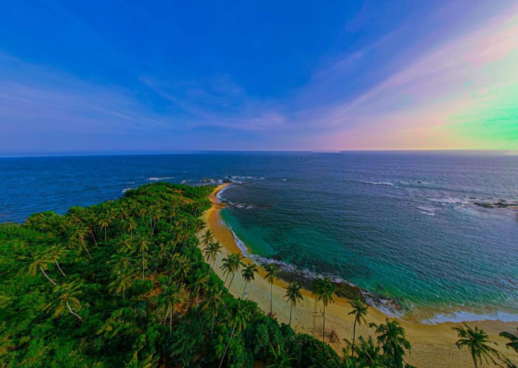 an aerial view of a beach with palm trees and the ocean at Sea Breeze Heaven in Tangalle