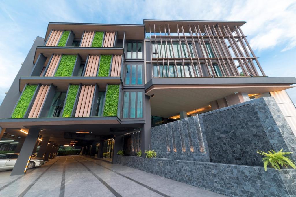 un montage d’un bâtiment avec des plantes sur celui-ci dans l'établissement Pause and Play Hotel, à Chiang Mai