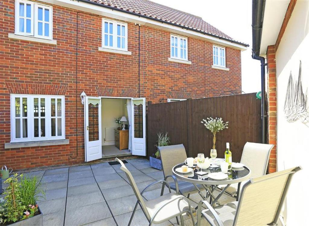 a patio with a table and chairs in front of a house at 3 Bed in Southwold oc-kit in Reydon
