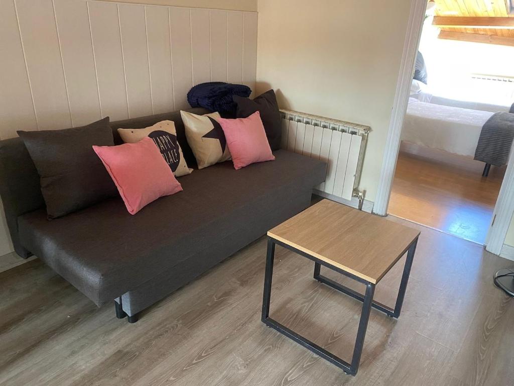 a couch with pillows on it in a living room at Ático El Hub in León