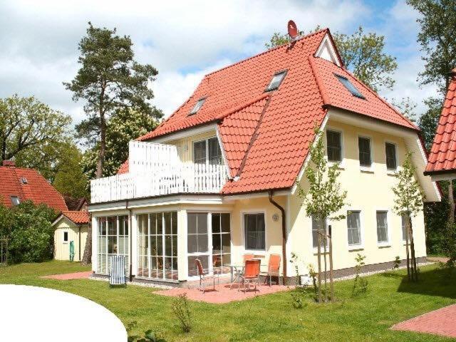 a large white house with an orange roof at Ferienwohnung Buchenpark in Prerow