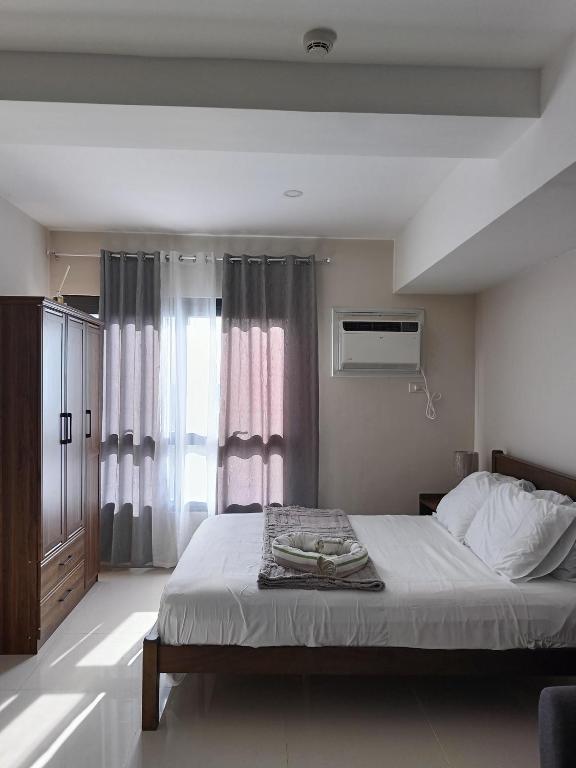 a bedroom with a bed and a window at Homey studio in jtower residences in Mandaue City