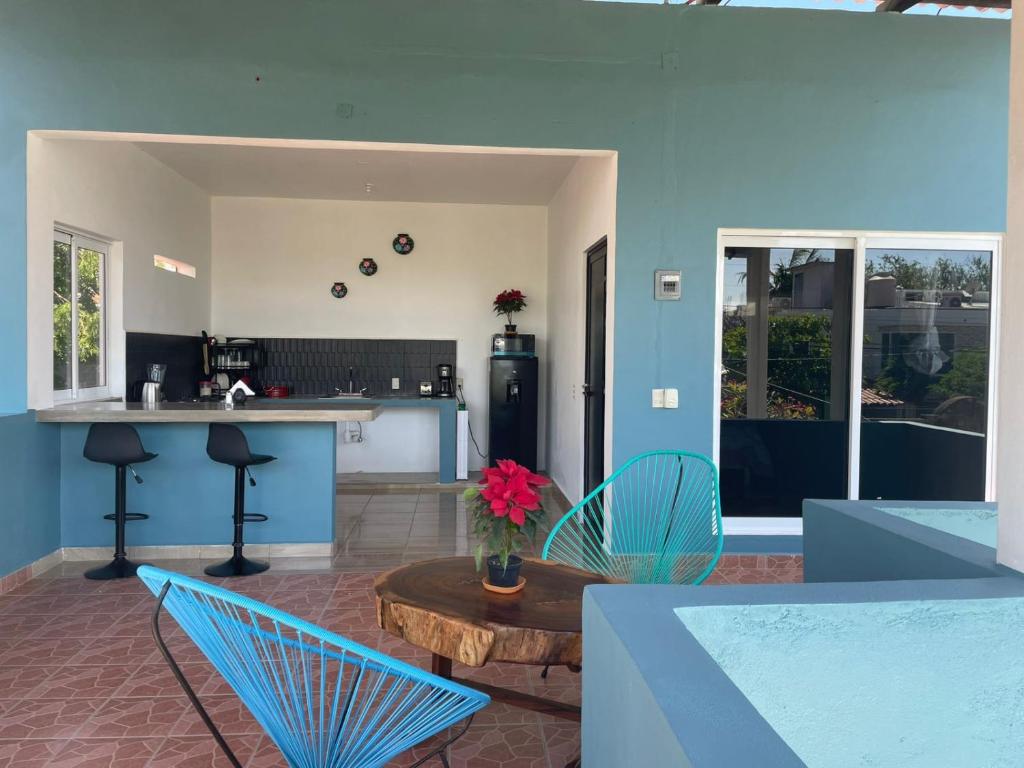a kitchen and living room with a table and chairs at Refugio del Mar in Puerto Escondido