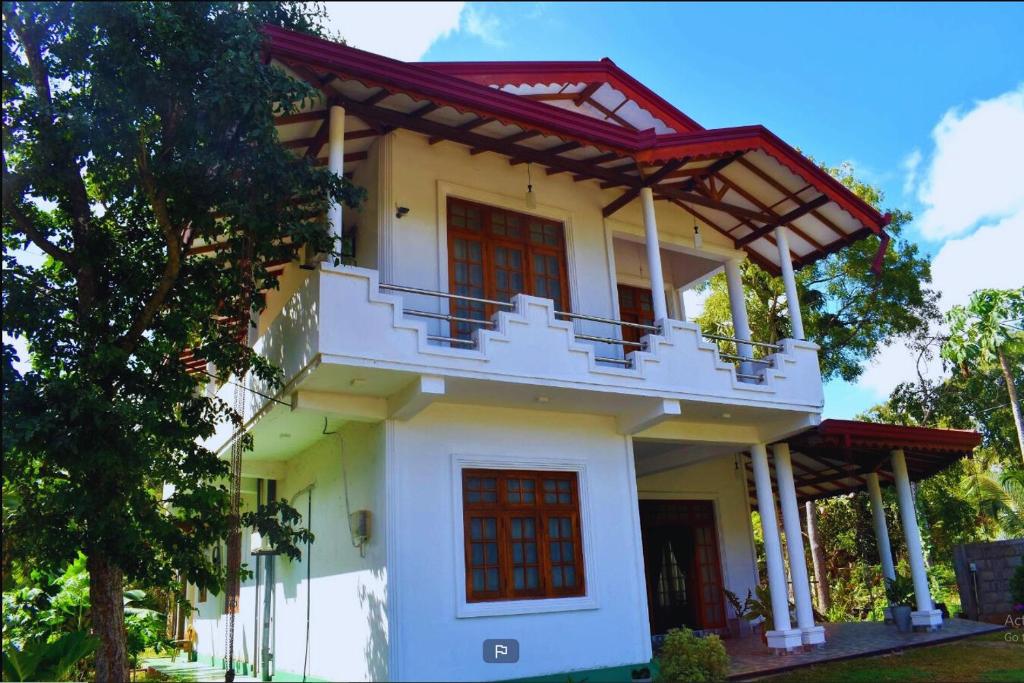a yellow house with red doors and a balcony at The European Gate - Anuradhapura in Anuradhapura