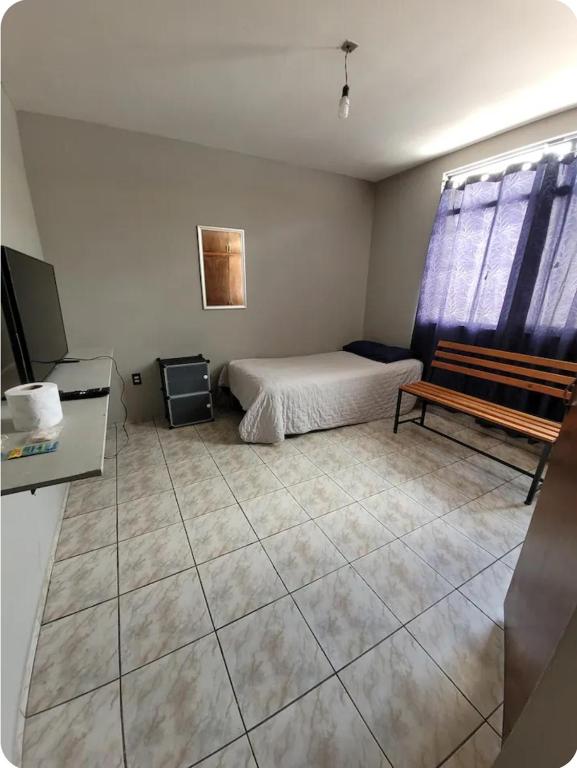 a bedroom with a bed and a bench in it at Habitaciones Comfort Centricas Durango in Durango