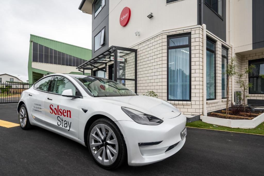 a white car parked in front of a building at Solsen Flexi-Stay & Motel in Auckland