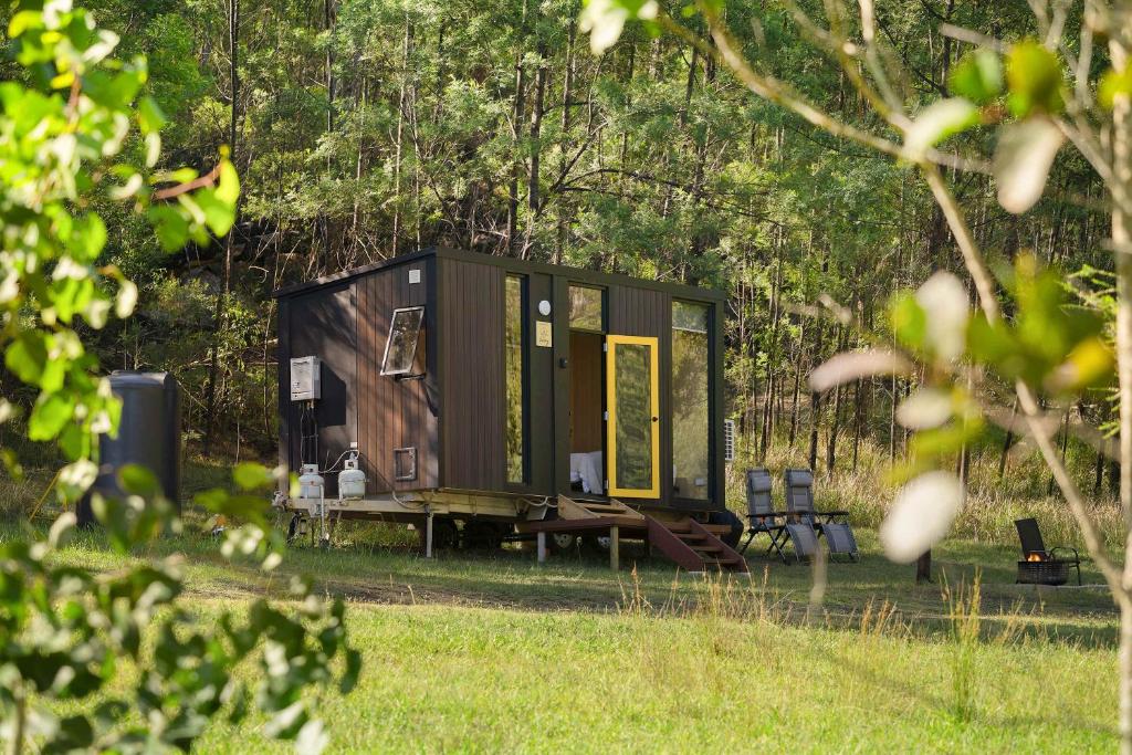 a tiny house in the middle of a field at Wombat Hideaway by Tiny Away in Laguna
