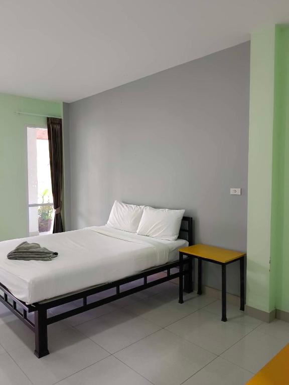 a bedroom with a bed with a table on it at โรงแรมสิริพรชัย 2 in Takua Pa