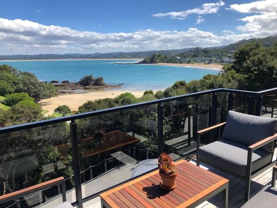 a balcony with a chair and a view of a beach at W91 Stylish, Modern, Beach view in Tutukaka