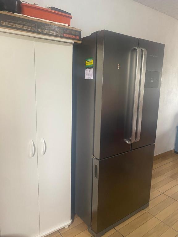a stainless steel refrigerator in a kitchen next to a cabinet at Posada - Letiéle in São Gabriel