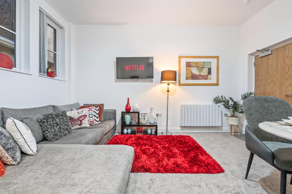 a living room with a couch and a red rug at Pleasant and snuggly modern 2-floored town centre apartment in Hull