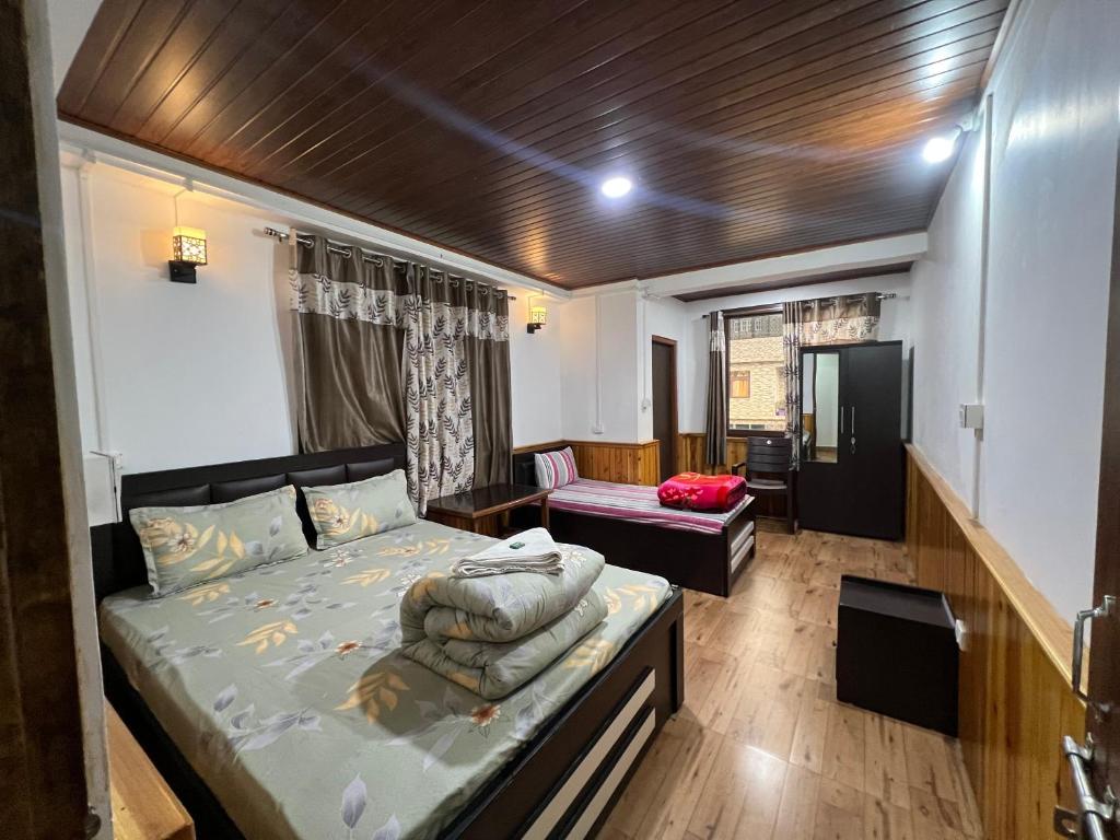 a bedroom with a bed and a chair in it at Hangkhim Homestay in Ravangla