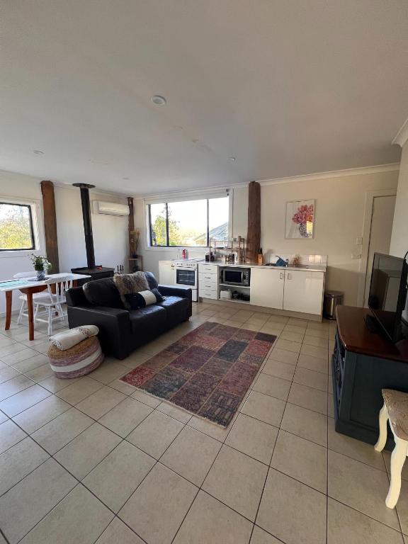 a living room with a couch and a table at Mulla Villa Farm cottage 1 in Wollombi