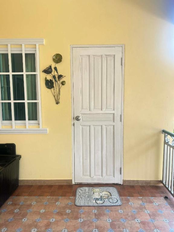 a white door with a mat in front of it at Baan Phakdee in Ban Phlong Takhe