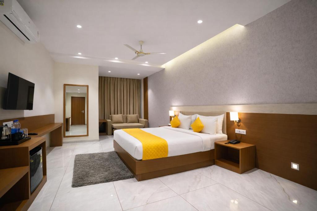 a hotel room with a bed and a television at Solasta Stays and Banquet - Wakad in Pune
