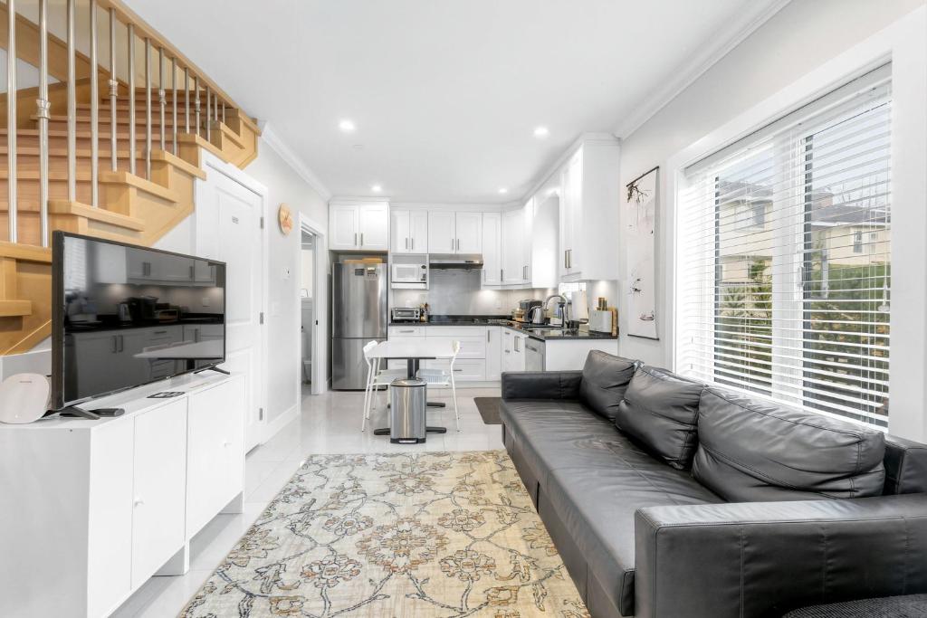 a living room with a couch and a kitchen at New laneway house near Airport, World Cup stadium, Downtown, UBC in Vancouver