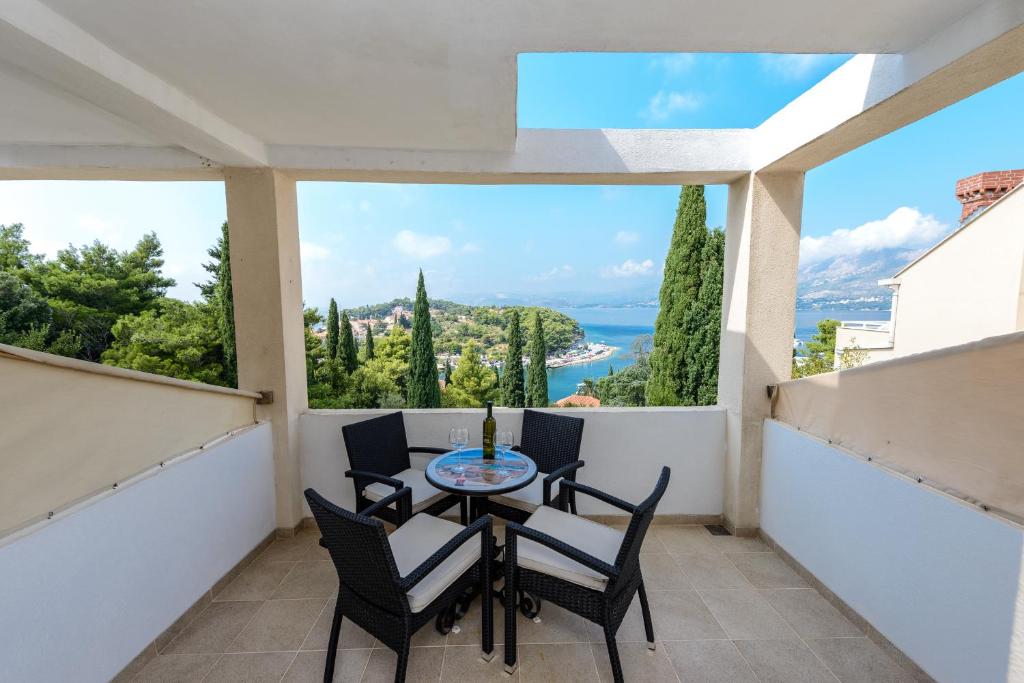 a balcony with a table and chairs and a view of the ocean at Apartments Aida in Cavtat