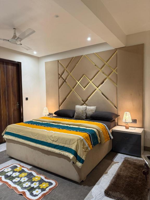 a bedroom with a large bed with a large headboard at The Social Haven-A Cozy Urban Retreat in Noida