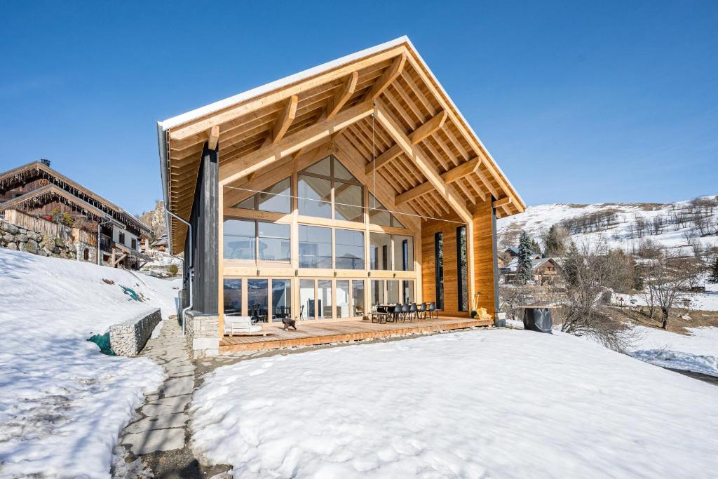 a wooden house in the snow in the winter at Black Arves in La Rochette