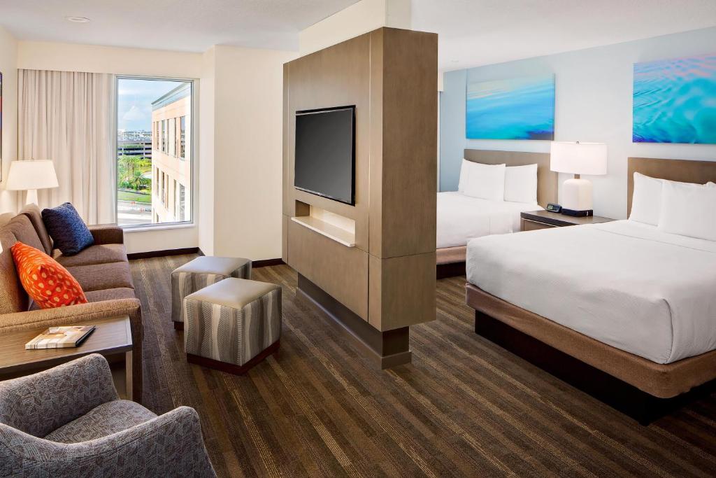 a hotel room with a bed and a tv at Hyatt House across from Universal Orlando Resort in Orlando