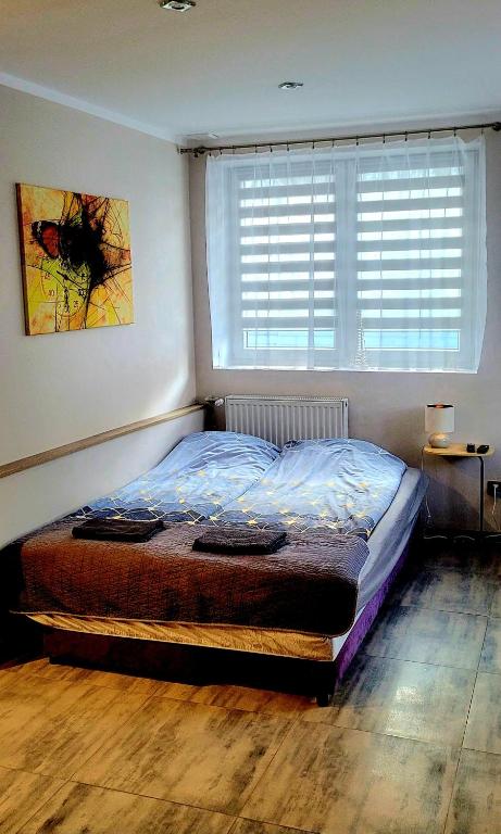 a bedroom with a bed and a window with blinds at Apartament Lipnicki 2 in Bielsko-Biała