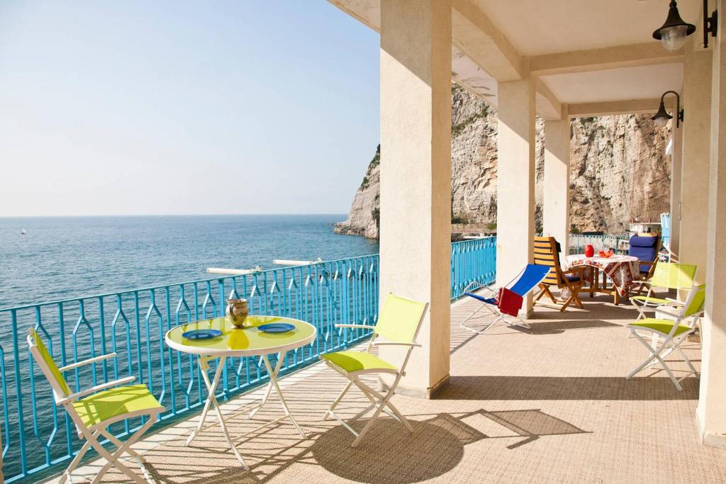 a balcony with chairs and a table and the ocean at terrazza metese in Meta