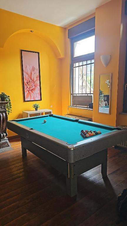 a pool table in a room with yellow walls at Charlemagne house in Liège