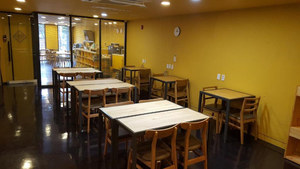 a room with tables and chairs in a restaurant at Seri Inn Guesthouse in Busan