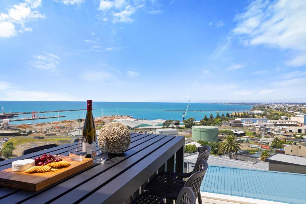 a balcony with a table and a view of the ocean at Seaview on Findlay in New Plymouth